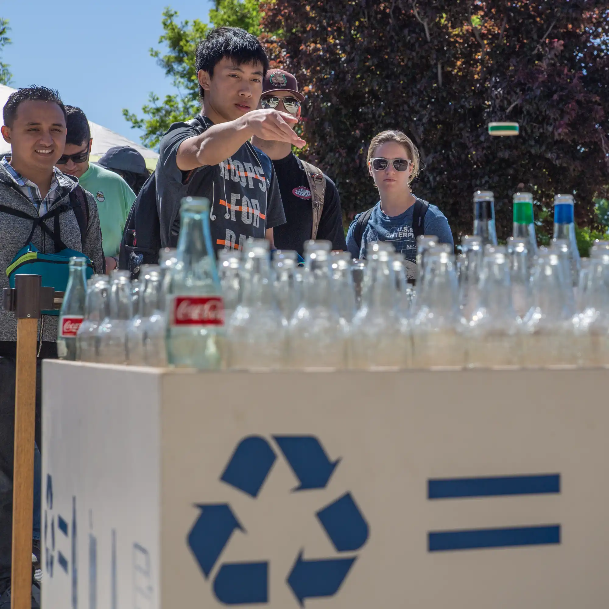 UC Merced community members playing a ring toss game made of recycled materials.